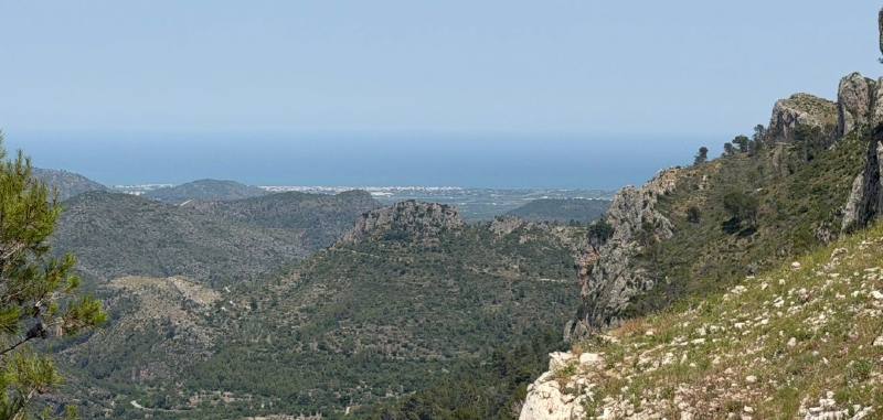 A wide view from the mountains across the valley towards the sea